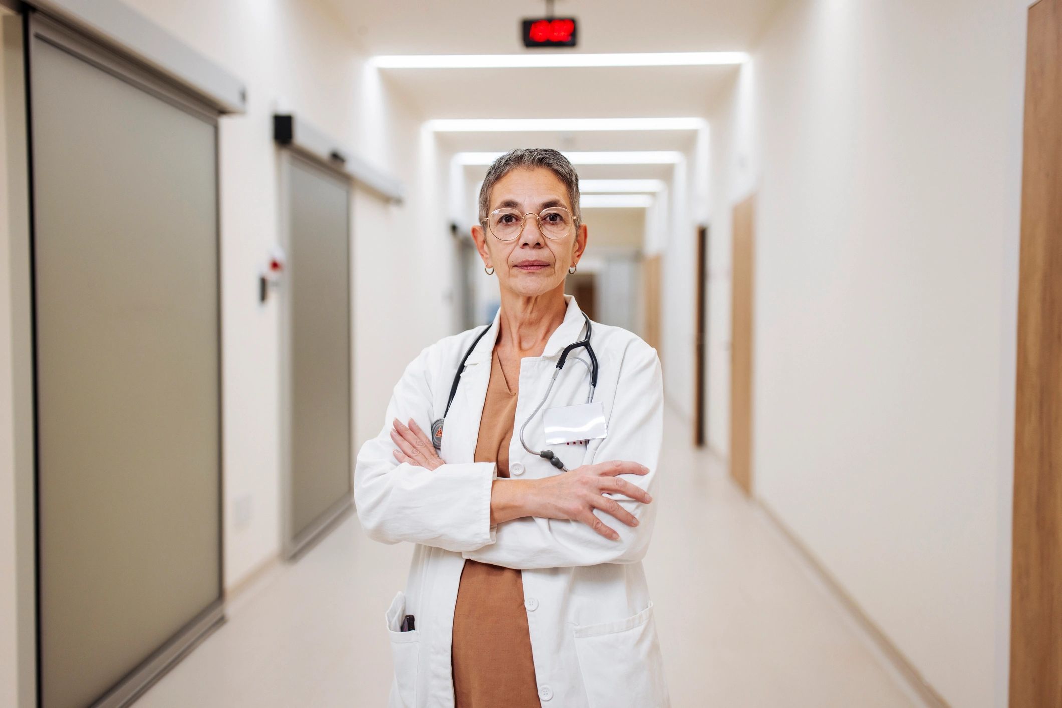 Confident physician standing in hospital corridor